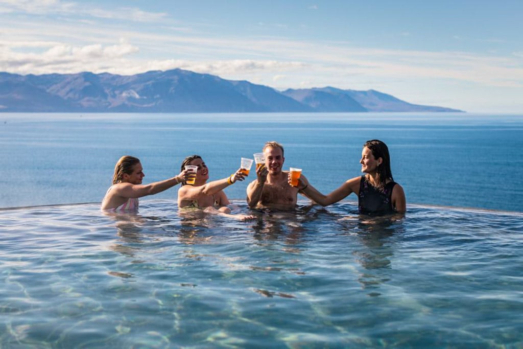 People enjoying their beers in the warm water infinity pool at GeoSea Baths in North of Iceland