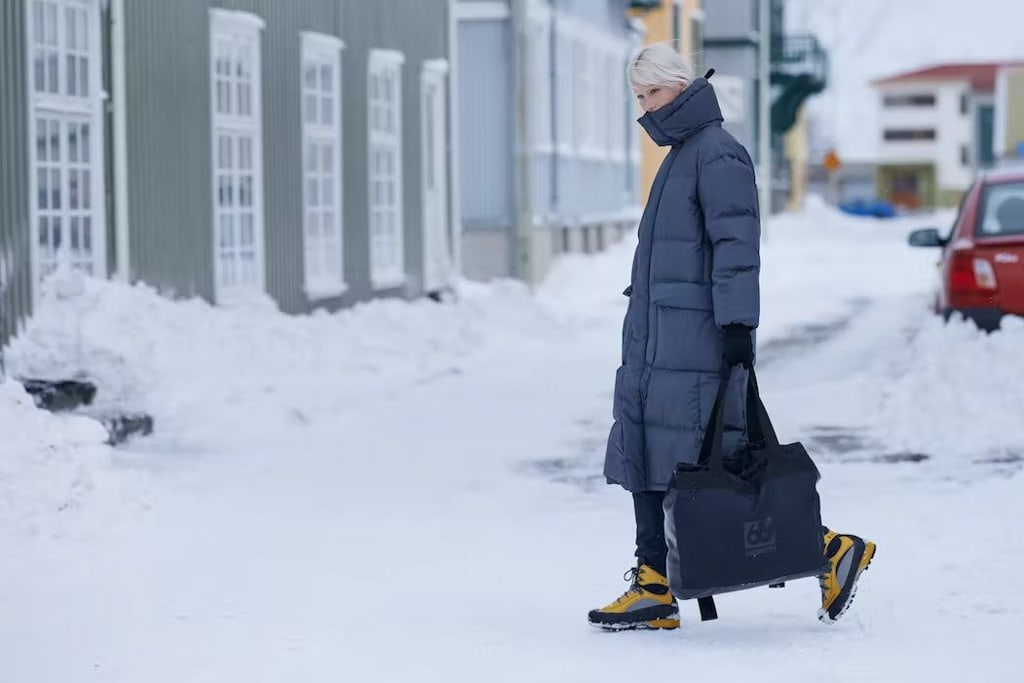 Local woman walking on the street in Reykjavík wearing a big winter parka  