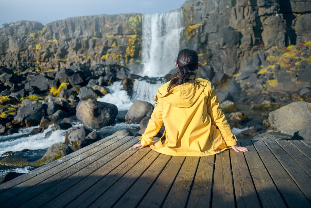 woman sitting infront of a waterfall