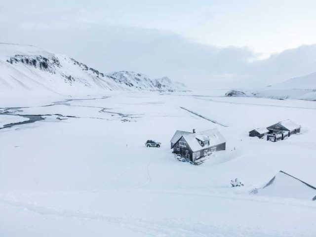 Remote cabins surrounded by snow in the Iceland Highlands on a Landmannalaugar tour.