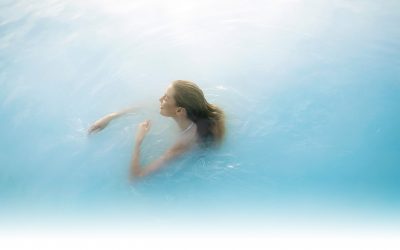 Woman floating in the milky water of Blue Lagoon in Iceland