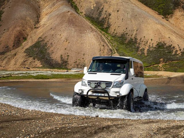 White superjeep driving out of a river in the Iceland Highlands on a Landmannalaugar tour.