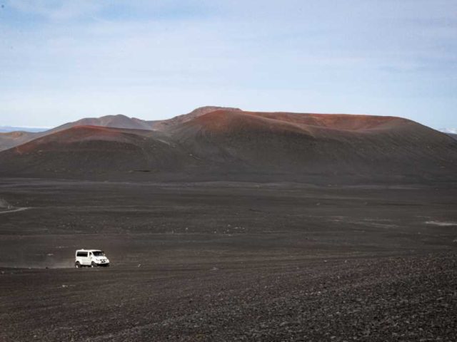 White superjeep traversing the rugged Iceland Highlands as part of a Landmannalaugar tour.