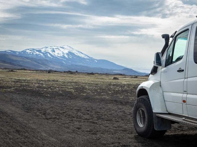 White superjeep parked in a vast landscape of the Iceland Highlands on a Landmannalaugar tour.