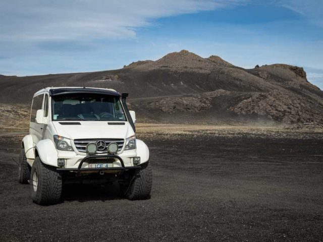 Superjeep driving on a barren terrain in the Iceland Highlands, part of a Landmannalaugar tour.