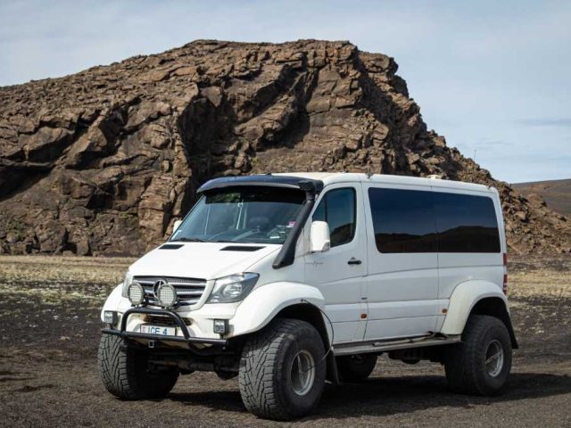 White superjeep parked in the rocky landscape of the Iceland Highlands on a Landmannalaugar tour.