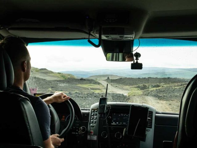 Interior view of a Landmannalaugar superjeep with driver navigating the Iceland Highlands.