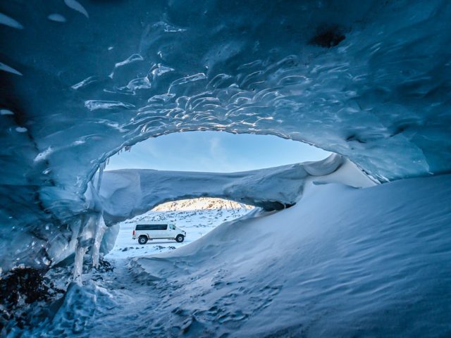 Tourists enjoying a guided ice cave exploration, a highlight of a luxury vacation in South Iceland.