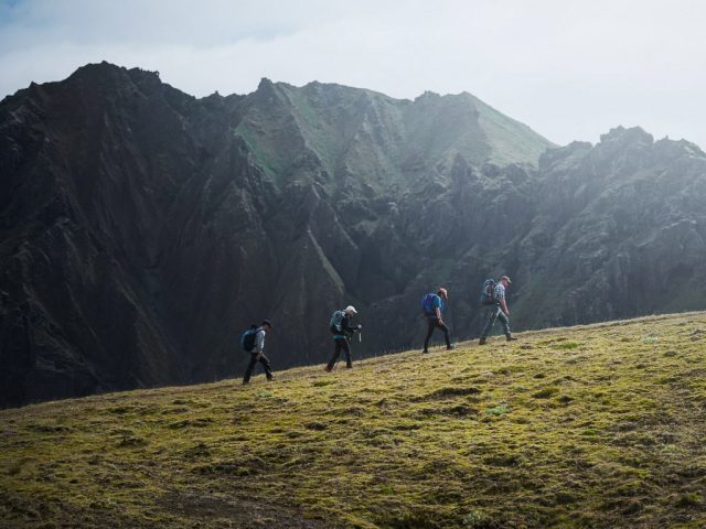 Hikers walking through a rocky mountain pass in Thórsmörk.